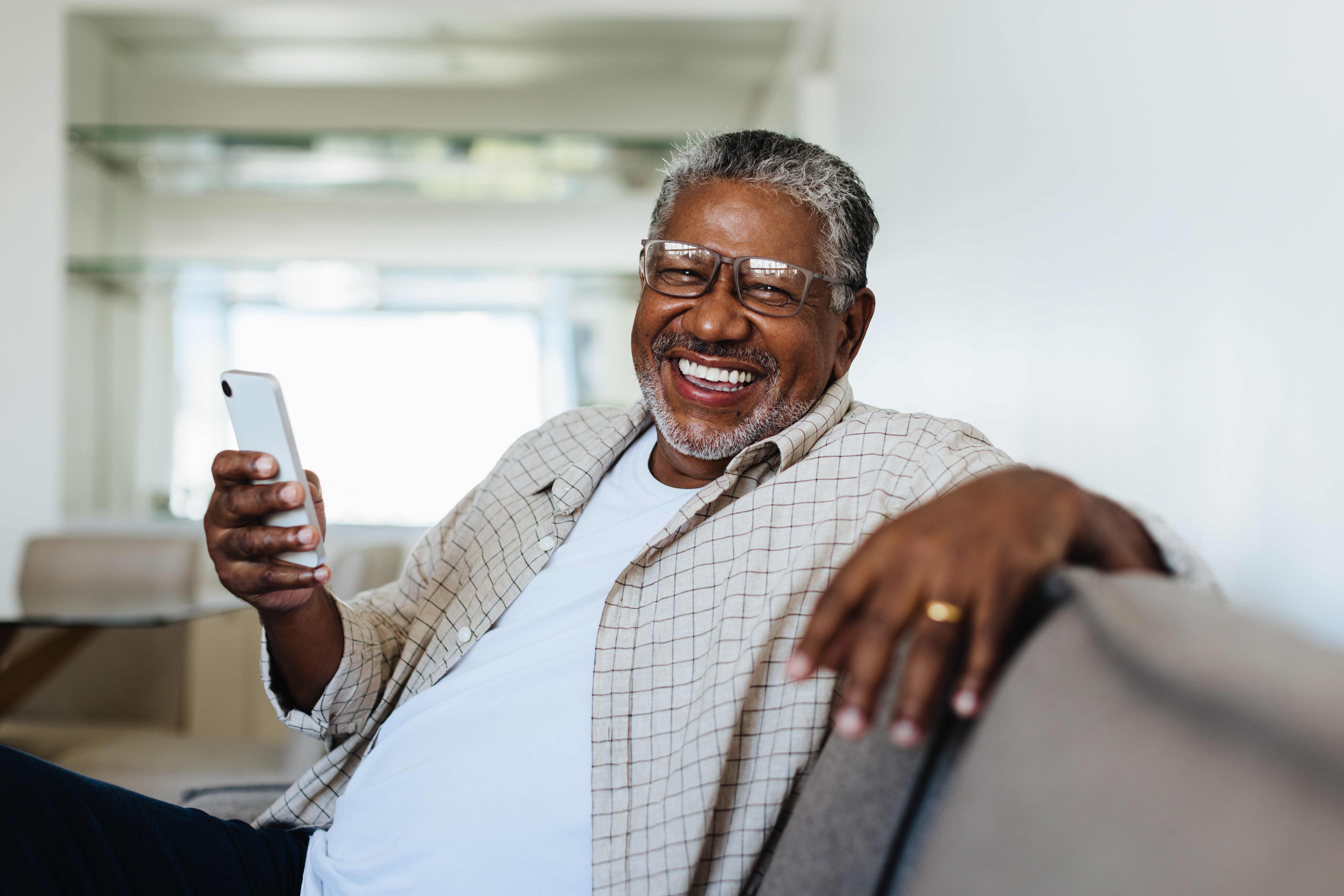 Senior man smiling while using his smartphone